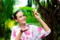 Gorgeous beautiful woman hold a leaf for closing her head when itÃ¢â¬â¢s raining.